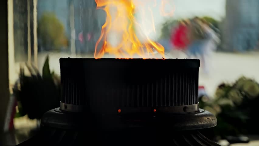 Gentle fire moves in slow motion, symbolizing sacrifice, silence and memory