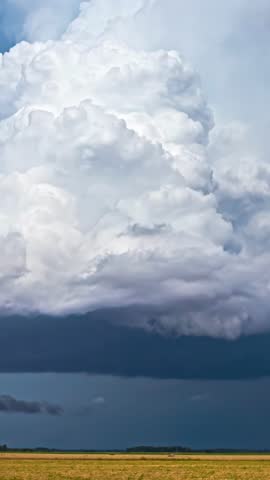 Cumulonimbus thunderstorm clouds timelapse over wheat agriculture cereal field during harvest