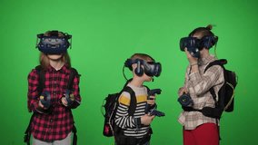 Youngsters engage in a simulated activity on a green backdrop, utilizing virtual reality headsets. They immerse themselves in 3D, 360-degree virtual reality videos. Chroma key. - Powered by Shutterstock - Get 15% off with code: PIKWIZARD15