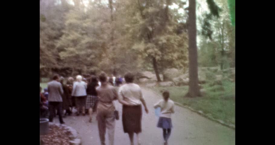 People walking in autumn park, rear view, unrecognizable. Archival video from 1970s, Ukraine