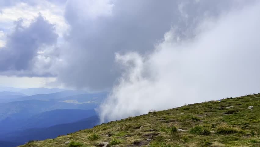 Clouds moving in and around mountain peak Hoverla in the Carpathians on a summers day. Clouds covering the mountains. 