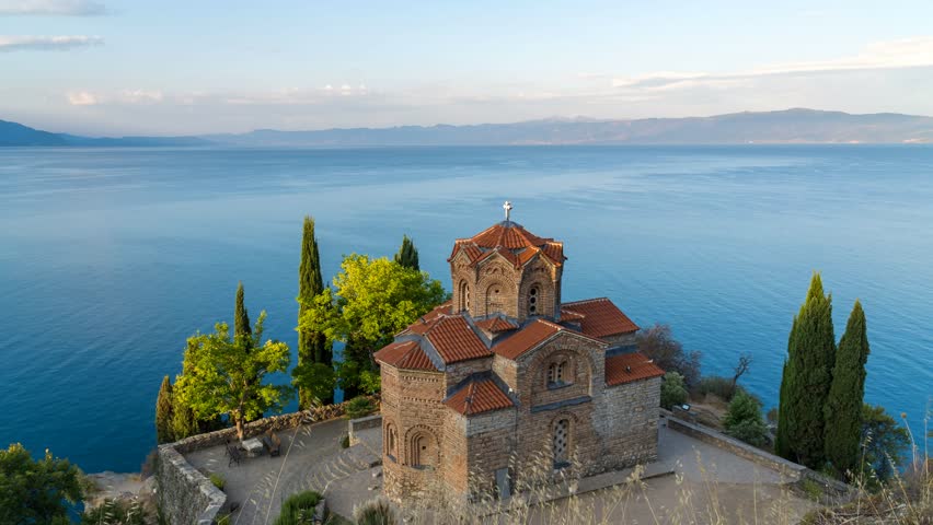 Sunlight illuminates the Church of St John, Kaneo, perched on the cliffs of lake Ohrid at sunrise. Time lapse