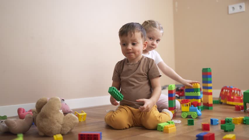 Three children playing with blocks. Children play together in a group. Build a new floor blocks for your kindergarten with toys and a constructor. Three kids engaging with building lifestyle.