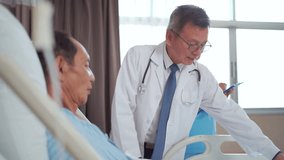 Asian doctor and medical nurse assistant visiting elderly male patient in hospital recovery room. Doctor discussing health condition while nurse records notes on tablet. Concept of healthcare, treatme - Powered by Shutterstock - Get 15% off with code: PIKWIZARD15