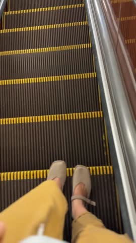 Feet standing on escalator with focus on shoes and steps. Captures modern urban transportation theme video