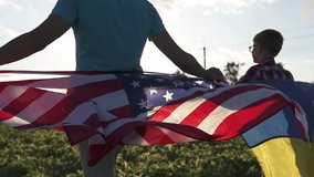 Father and son hold American and Ukrainian flags. Symbol of US support for Ukraine during the war. - Powered by Shutterstock - Get 15% off with code: PIKWIZARD15