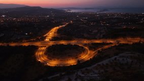 A stunning time lapse or hyperlapse aerial video of a large roundabout at night with car headlights and taillights creating mesmerizing trails of light a view of urban infrastructure - Powered by Shutterstock - Get 15% off with code: PIKWIZARD15