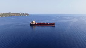 Drone ascends and descends while advancing around a red oil tanker near the Sicilian coast, with calm blue waters and distant vessels. - Powered by Shutterstock - Get 15% off with code: PIKWIZARD15