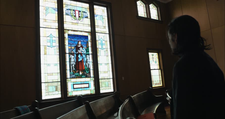 A Christian man, priest, preacher, pastor in spiritual reflection and worship while praying inside old church building, creating a cinematic and contemplative mood.