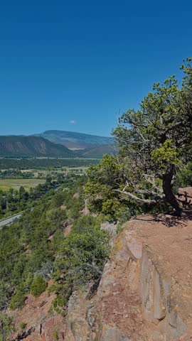 Vertical, overlooking grassy hill and rugged terrain distant mountains, Red Hill Carbondale Colorado