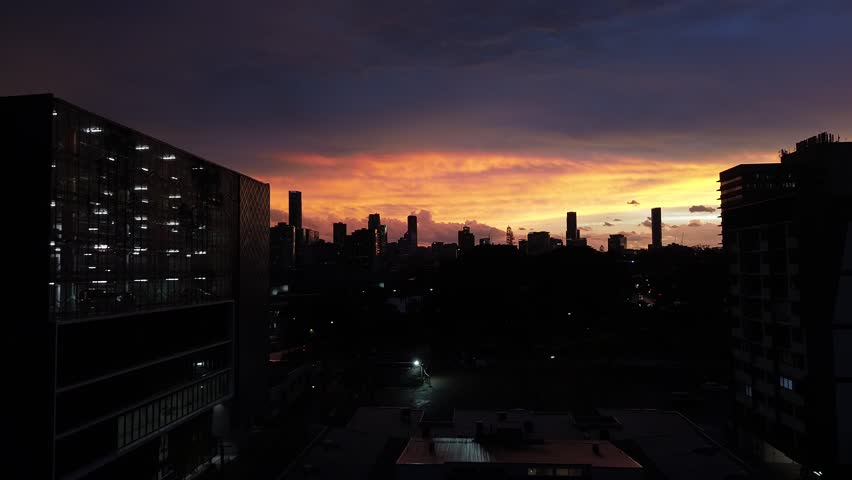 Aerial drone view of Brisbane city skyline at sunset with colorful sky, modern skyscrapers and urban landscape in Queensland, Australia
