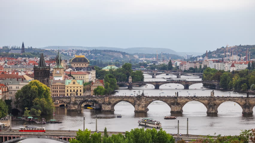 Timelapse of Prague cityscape as daylight fades into night, Charles Bridge and historic skyline glowing with evening lights. High quality 4k footage
