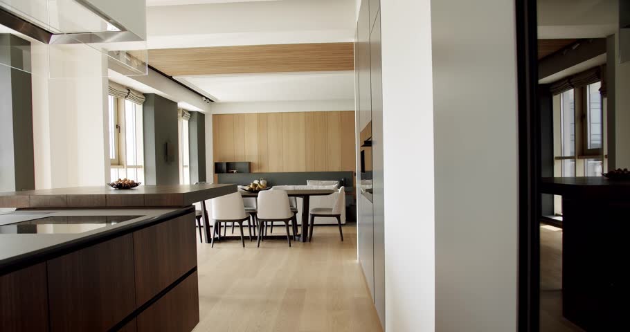 Modern interior in luxury house. Interior of a minimalist kitchen. Light Wood Wall and Floors. Modern kitchen and bar brown chairs in kitchen room in minimalist apartment.