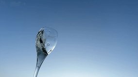 Champagne splashes from champagne glass on sunset blue sky. Romantic glass of white wine with bubbles, splashes. Champagne spilling from glass. Sparkling wine bubbles splash. Vibrant liquid splashing. - Powered by Shutterstock - Get 15% off with code: PIKWIZARD15