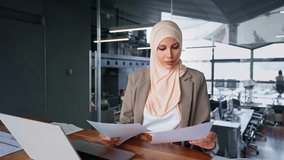 Focused Indian or arabian businesswoman working in office. Copy space. Middle eastern muslim woman in hijab using laptop computer for business analysing, trading, banking, financial data or insurance - Powered by Shutterstock - Get 15% off with code: PIKWIZARD15