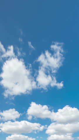 Beautiful blue sky timelapse with soft white clouds moving forward. Picturesque abstract cloudscape during a sunny summer day, perfect for a serene background or peaceful atmosphere.