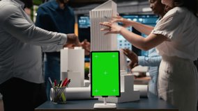 Engineers team share master plan ideas next to chroma key display, using 3D architectural models and blueprints for construction layout details. Modern design city planning in a session. Camera A. - Powered by Shutterstock - Get 15% off with code: PIKWIZARD15