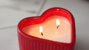 Red heart-shaped candle with two burning wicks creating warm romantic atmosphere with soft candlelight and gentle flames. Valentine Day romance, love celebration and intimate home decoration. - Powered by Shutterstock - Get 15% off with code: PIKWIZARD15