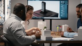 Real estate professionals engage in meeting to review blueprints and 3D models, planning for a large scale urban development project aimed at housing and infrastructure growth. Camera B. - Powered by Shutterstock - Get 15% off with code: PIKWIZARD15