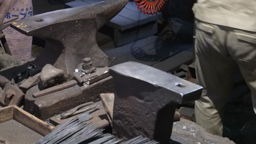 A craftsman removes a knife after annealing