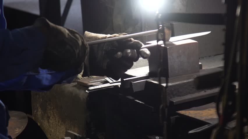 A craftsman stamping a knife
