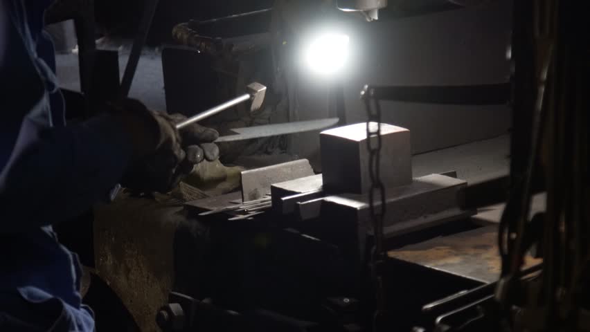 A craftsman stamping a knife