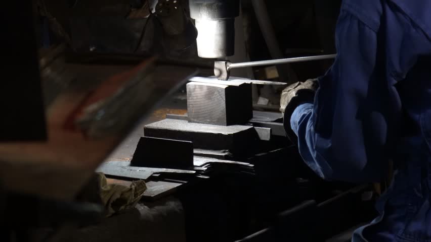 A craftsman stamping a knife