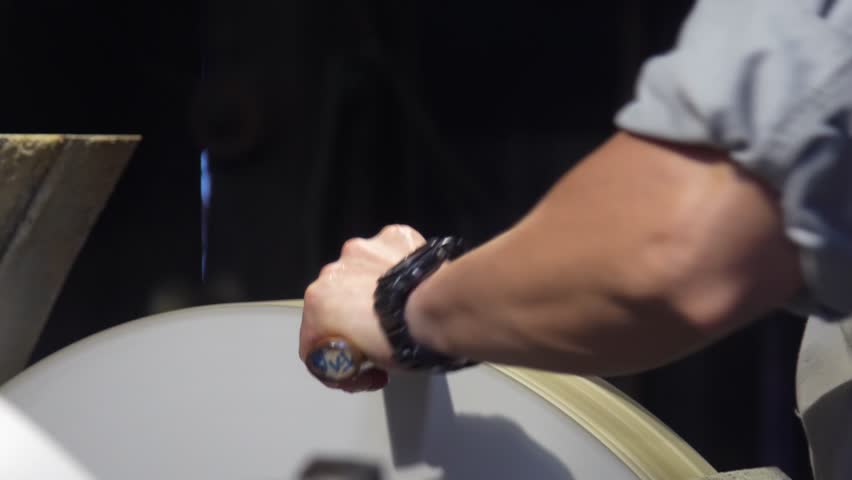 A craftsman sharpening a knife using a grinder