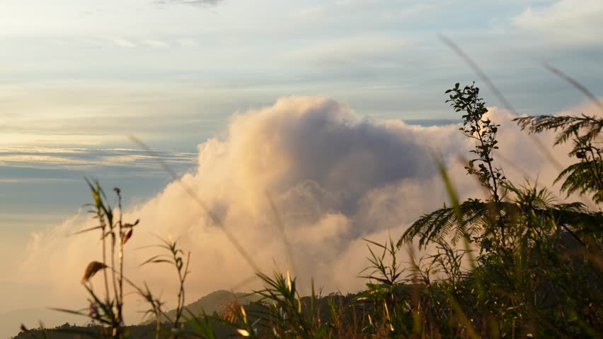 Majestic clouds illuminated by golden light drift over genting highlands, malaysia