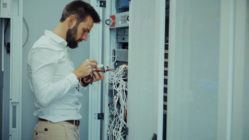 IT Engineer Working In Server Roomю Technician Repairing Network, Data Center Maintenance. Cybersecurity Cloud Computing Infrastructure. Network Administration, Server Rack. Server Room Security Wire - Powered by Shutterstock - Get 15% off with code: PIKWIZARD15