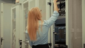Female IT Specialist Working With Server Rack Inside Modern Data Center. Professional System Administrator Managing Network Equipment And Configuring Hardware Connections. Cybersecurity Solutions Data - Powered by Shutterstock - Get 15% off with code: PIKWIZARD15