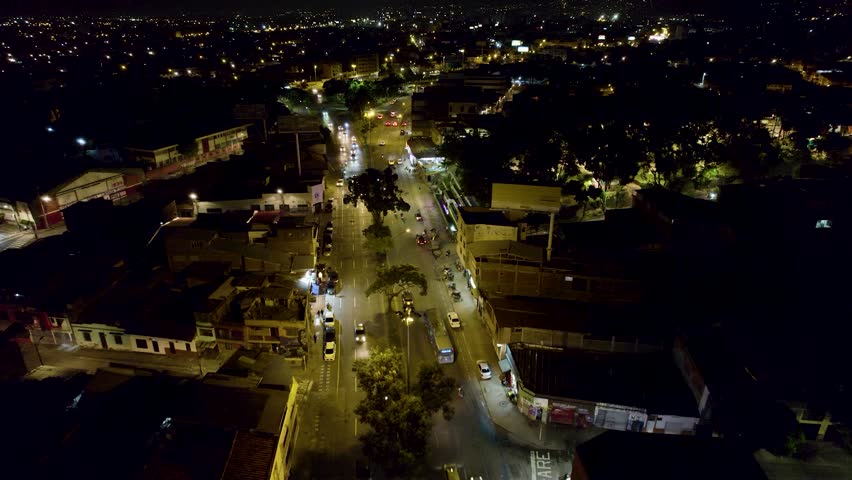 Aerial drone footage of Cali Valle del Cauca Colombia at night showing illuminated cityscape and urban skyline.