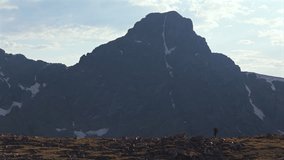 Hiker walking Notch Mountain shelter Halo Ridge landscape view of Mount of the Holy Cross 14er peak wilderness aerial drone Colorado summer afternoon sunset clouds Rocky Mountains Sawatch Range - Powered by Shutterstock - Get 15% off with code: PIKWIZARD15