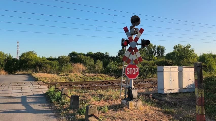 A rural railway crossing without  safety barrier, warning lights and acoustic signal,  electric overhead power lines  in Prahova County , Romania