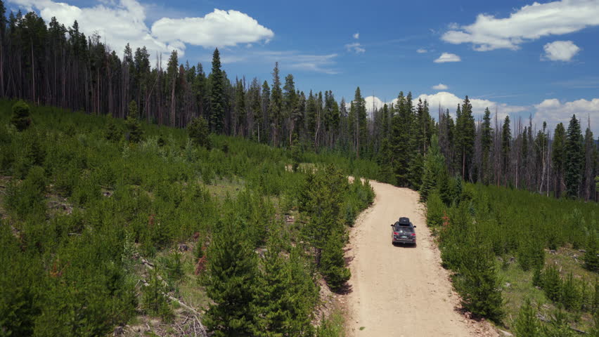 Mount of the Holy Cross Notch Mountain creek Falls Creek Trail Half moon pass AWD car driving dirt road car aerial drone Rocky Mountains Colorado Vail Minturn Red Cliff summer morning blue sky follow
