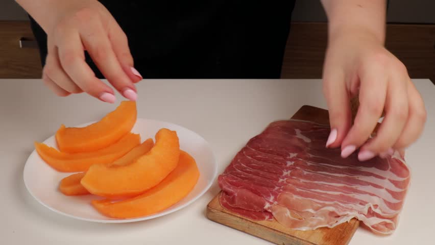 Wrapping prosciutto around melon slices, traditional Italian dish