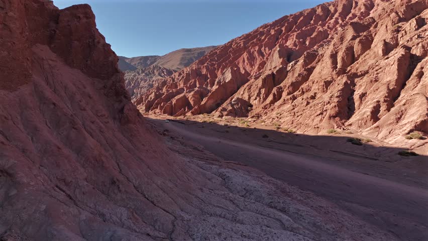 Aerial view of the majestic Valle del Arcoiris, with its vibrant red rock formations contrasting against the vast desert landscape, Valle del Arcoiris, San Pedro de Atacama, Chile.