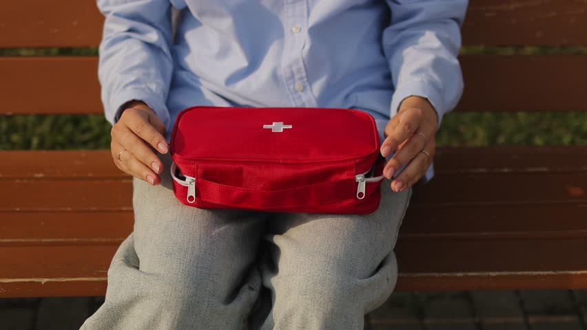 First aid kit. In the park on a bench. First aid kit close-up. Slow motion. High-quality video in 4K format.