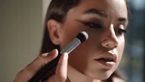 A closeup view of a makeup application on a model with a brush, emphasizing various beauty techniques and artistry - Powered by Shutterstock - Get 15% off with code: PIKWIZARD15