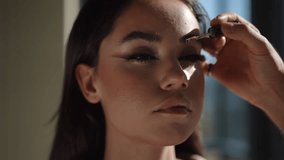 A makeup artist applies vibrant cosmetics to a model, showcasing various techniques and artistry beautifully - Powered by Shutterstock - Get 15% off with code: PIKWIZARD15