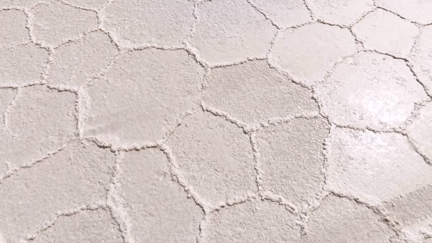 Aerial view of the stunning geometric patterns etched across the vast, arid expanse of the Salar de Uyuni salt flats, Potosi Department, Bolivia.