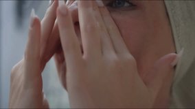 Young pretty woman applying moisturizer on her face during daily self care skincare treatment, close up shot. Beauty maintenance routine concept. - Powered by Shutterstock - Get 15% off with code: PIKWIZARD15