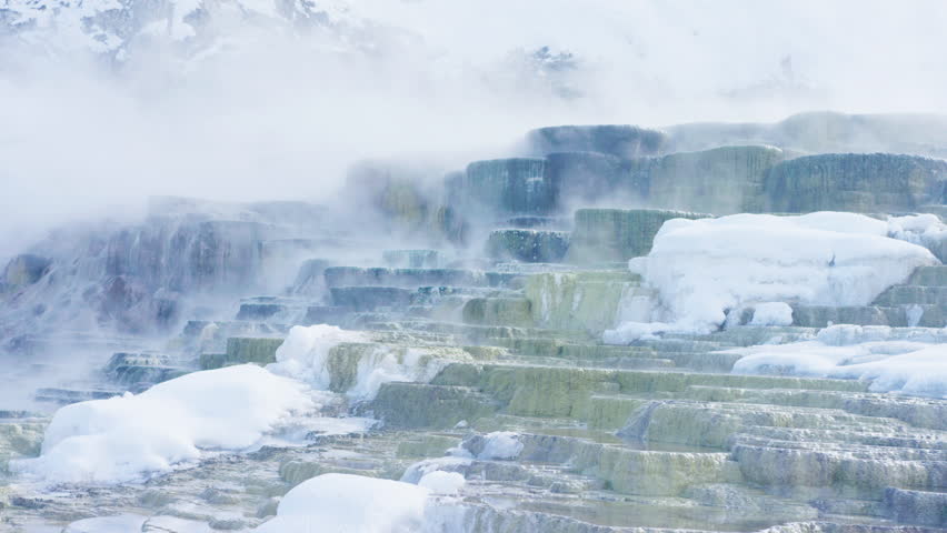 Steam over rocky landscape at Yellowstone National park in winter, Montana, US.