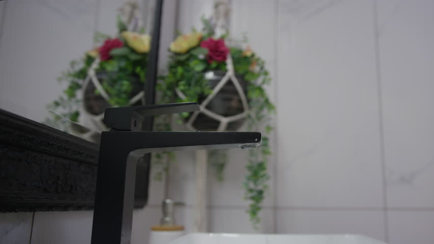 Young woman with a turban, a hair towel wrap around head, washing her face in the bathroom, slow motion shot. Beauty and body care routine concepts.