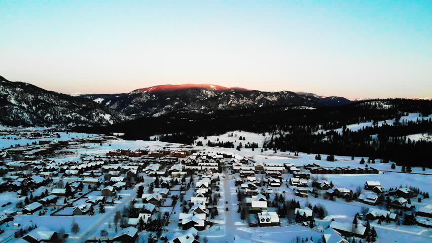 Aerial of a mountain landscape and a village at sunset, Big Sky, Montana, US.