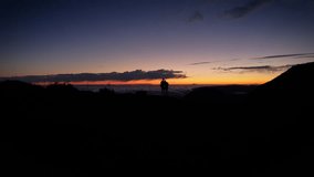 silhouette of a couple viewing sunset nightsky on a mountain top, Aerial exploration highlighting Pico do Arieiro in Madeira, vivid mountain ridges and peaks highlighted by radiant daylight. - Powered by Shutterstock - Get 15% off with code: PIKWIZARD15