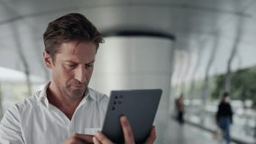 Portrait of serious man entrepreneur controls commercial activity via digital tablet in office. Mature businessman studies stock market trends with mobile device in business center - Powered by Shutterstock - Get 15% off with code: PIKWIZARD15