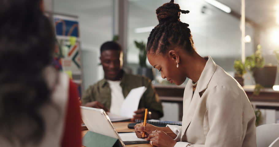 Woman, writing and team in office for graphic design, tablet and happy for brainstorming at company. Person, designer group and notebook for notes, smile or editing for project at creative agency