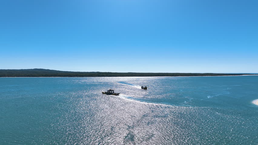 Flight over the azure waters of the Great Sandy Strait separating mainland Australia from Fraser K