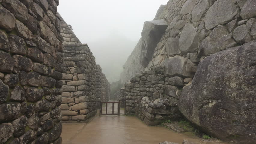 Slow motion video of Inca stone structures inside Machu Picchu, showing ancient walls and architecture in Peru